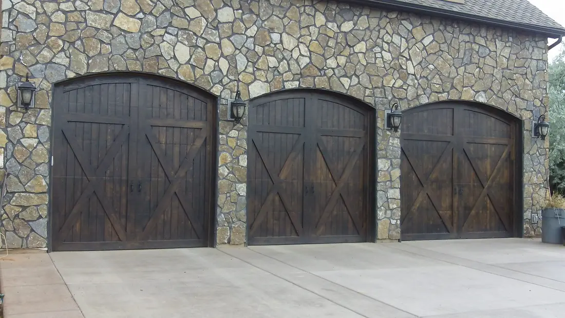 Three carriage-style garage doors set in stonework