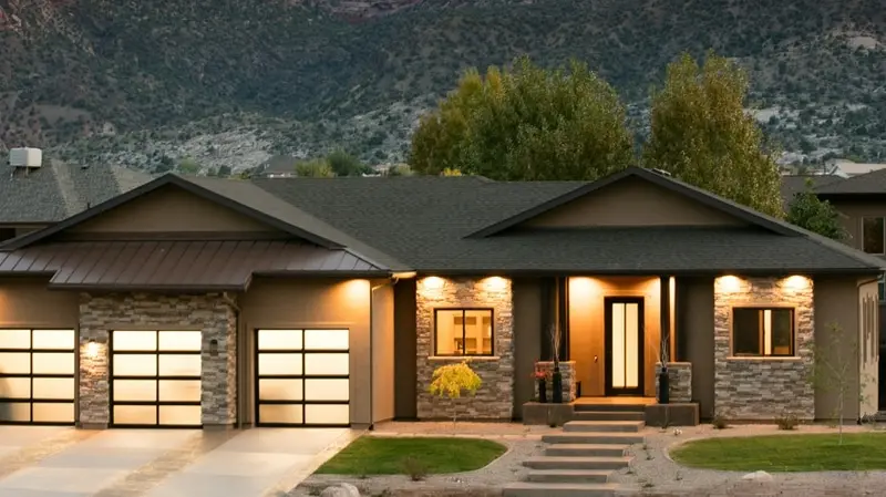 Modern home with lit glass garage doors